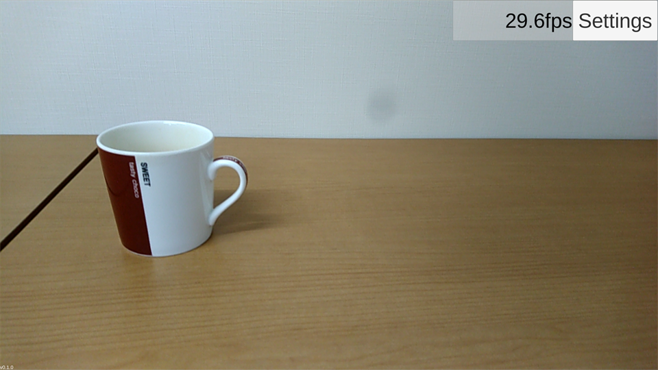 Color component output showing a cup on a table in fron of a white wall.